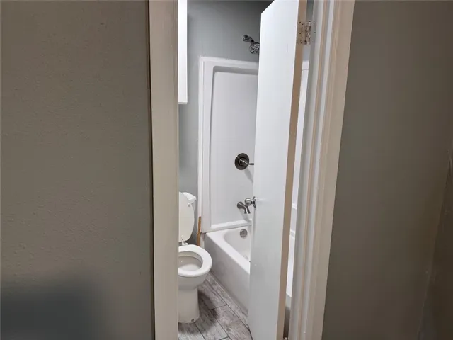 a bathroom with a toilet and a shower