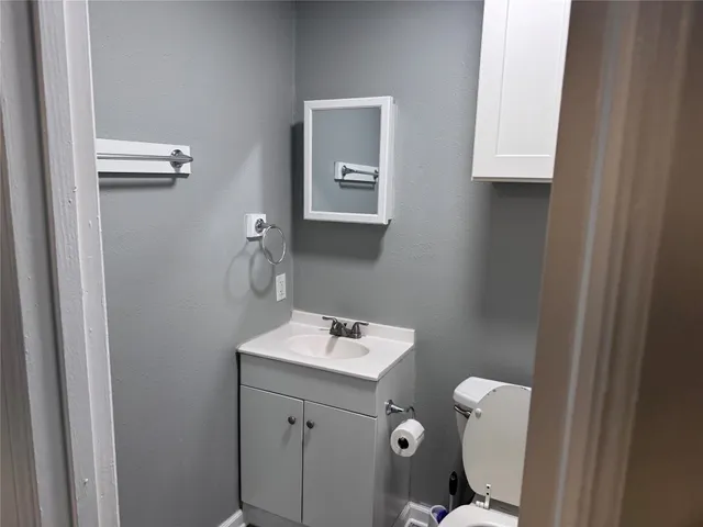 a bathroom with a toilet sink and mirror