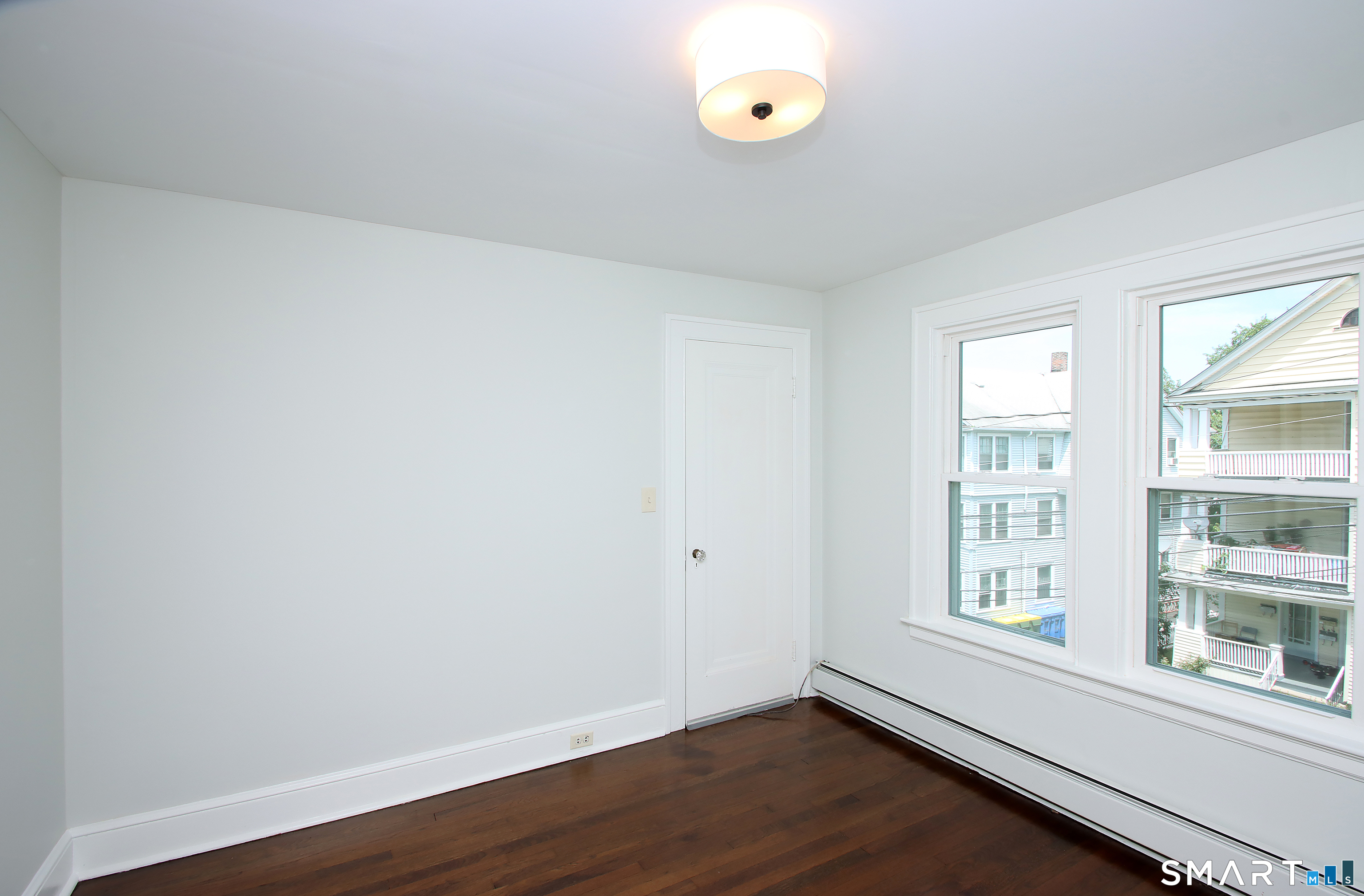217 Ledgeside Avenue Waterbury, CT 06708 - Photo 17 of 24 an empty room with wooden floor and windows
