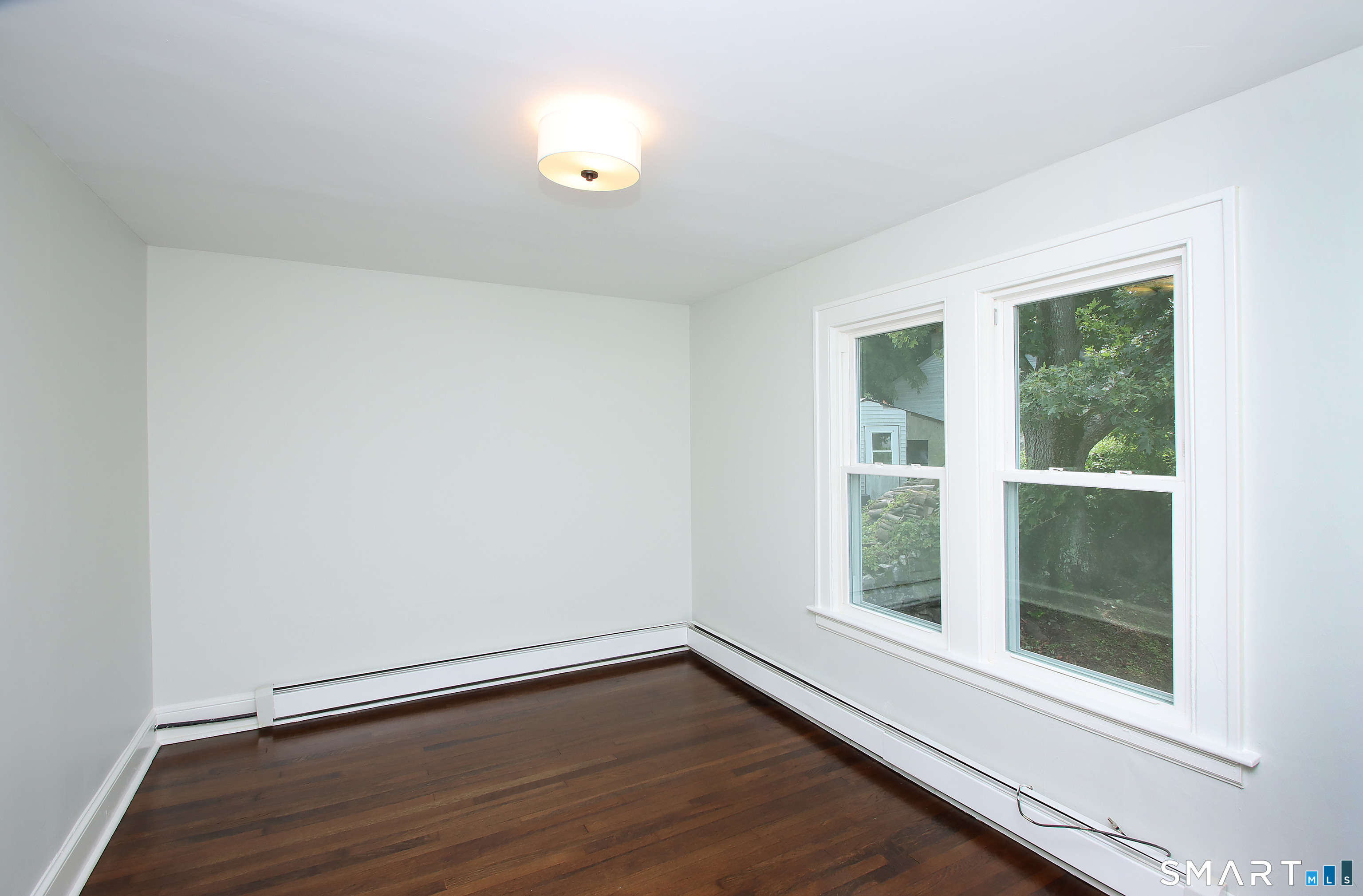 217 Ledgeside Avenue Waterbury, CT 06708 - Photo 18 of 24 a view of an empty room with wooden floor and a window