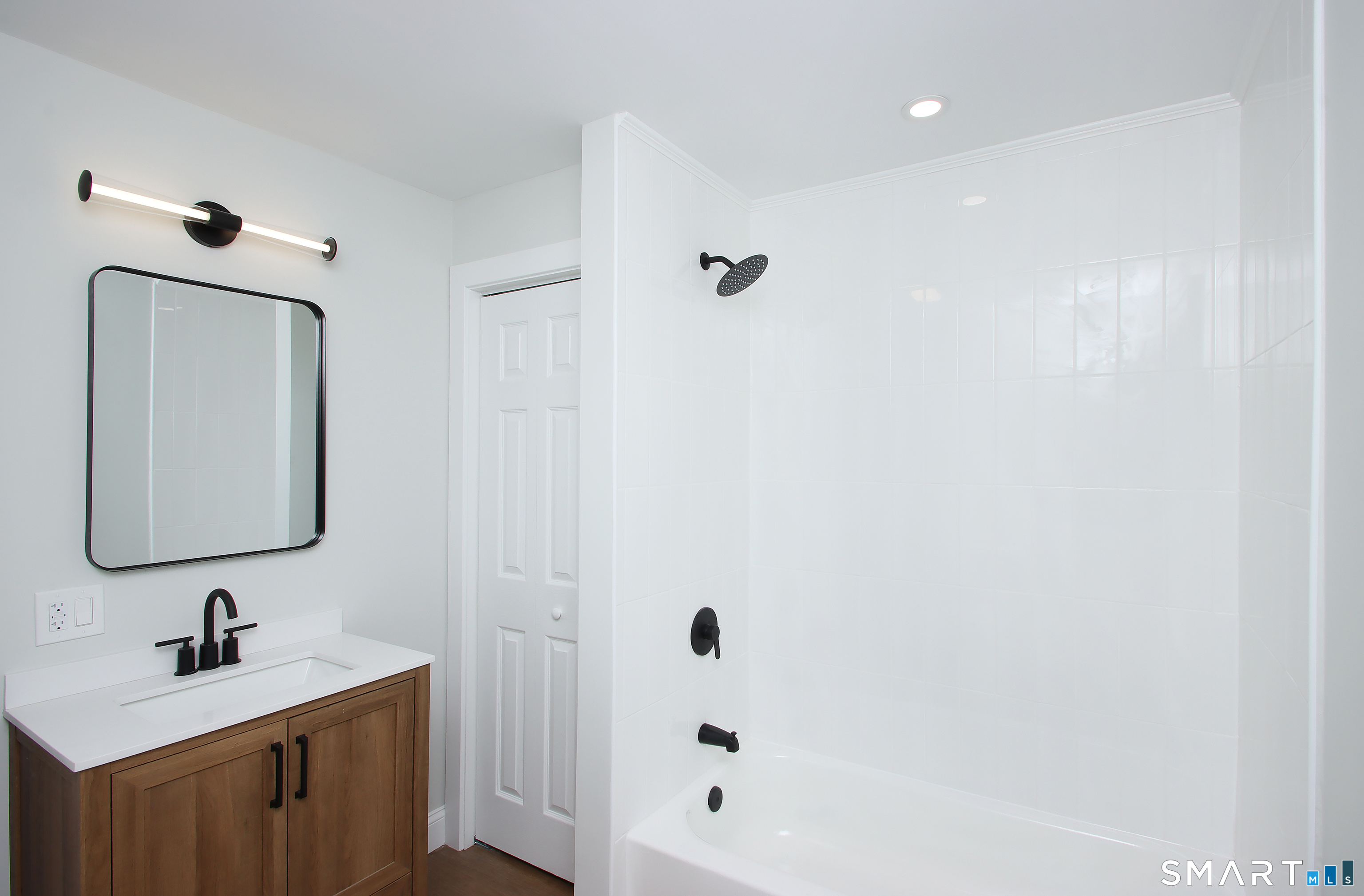 217 Ledgeside Avenue Waterbury, CT 06708 - Photo 20 of 24 a bathroom with a bathtub sink vanity and mirror