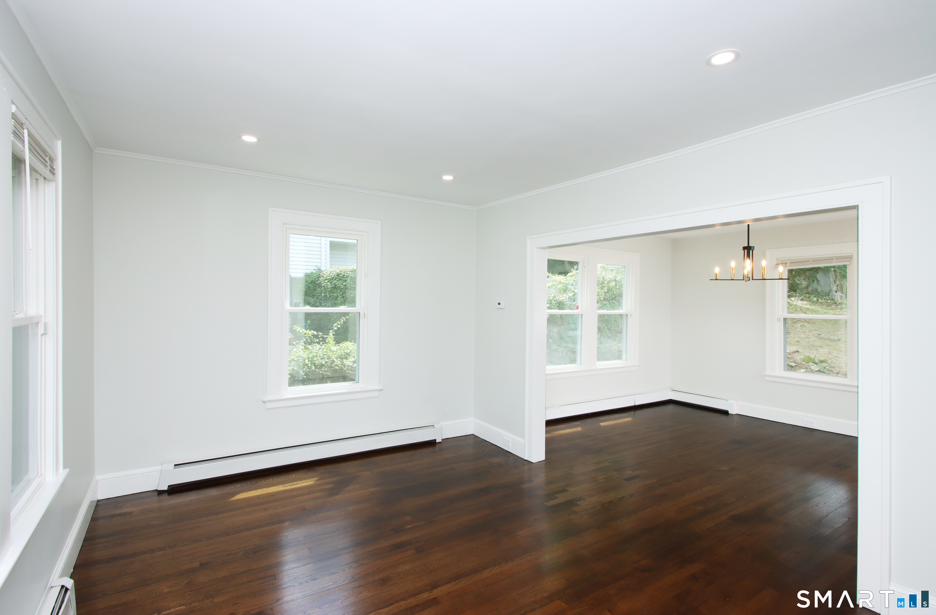 217 Ledgeside Avenue Waterbury, CT 06708 - Photo 5 of 24 an empty room with wooden floor and windows