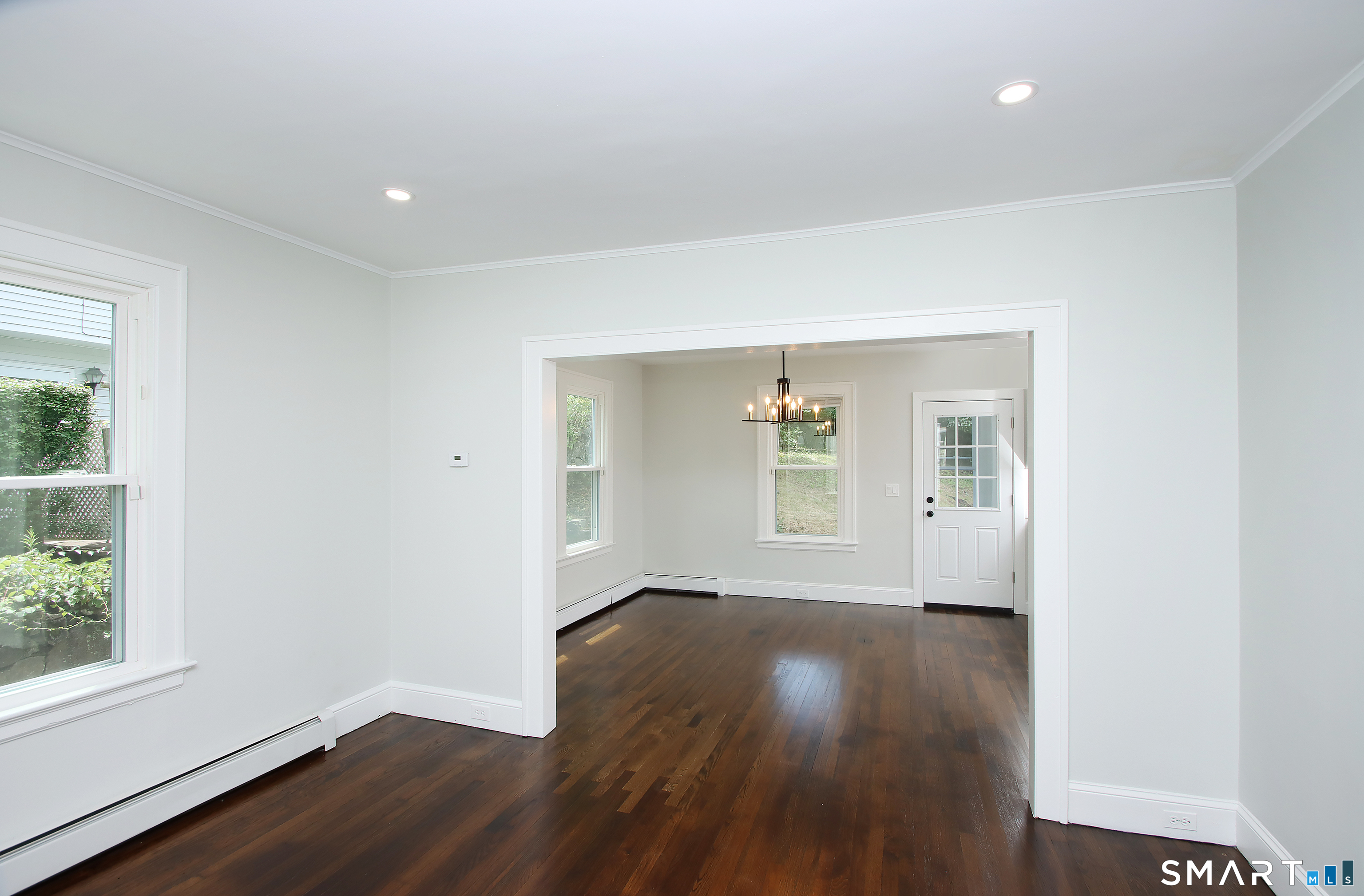 217 Ledgeside Avenue Waterbury, CT 06708 - Photo 6 of 24 an empty room with wooden floor and windows