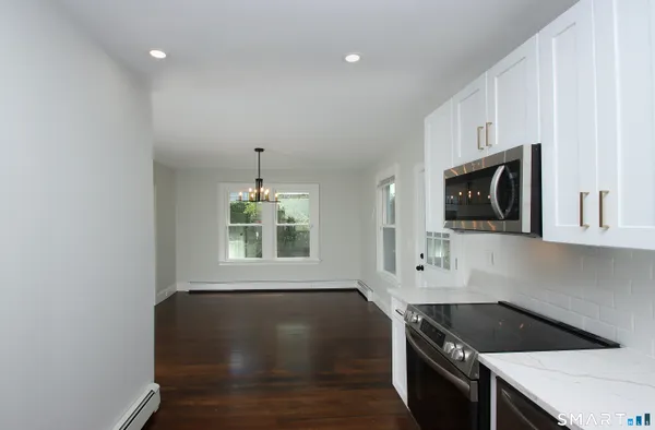 a kitchen with granite countertop a stove a sink and a microwave