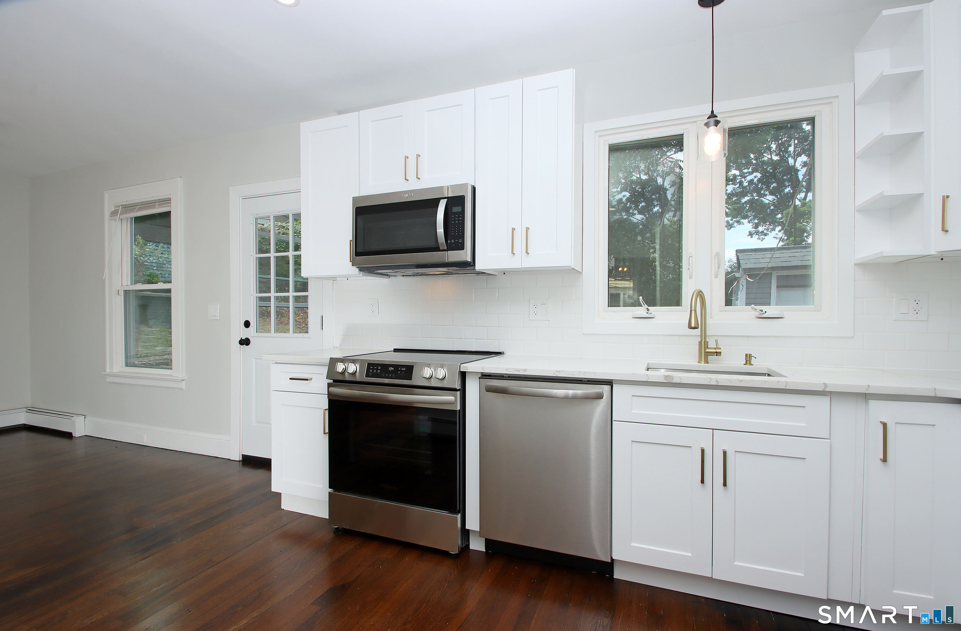 217 Ledgeside Avenue Waterbury, CT 06708 - Photo 9 of 24 a kitchen with cabinets stainless steel appliances a sink and a wooden floor