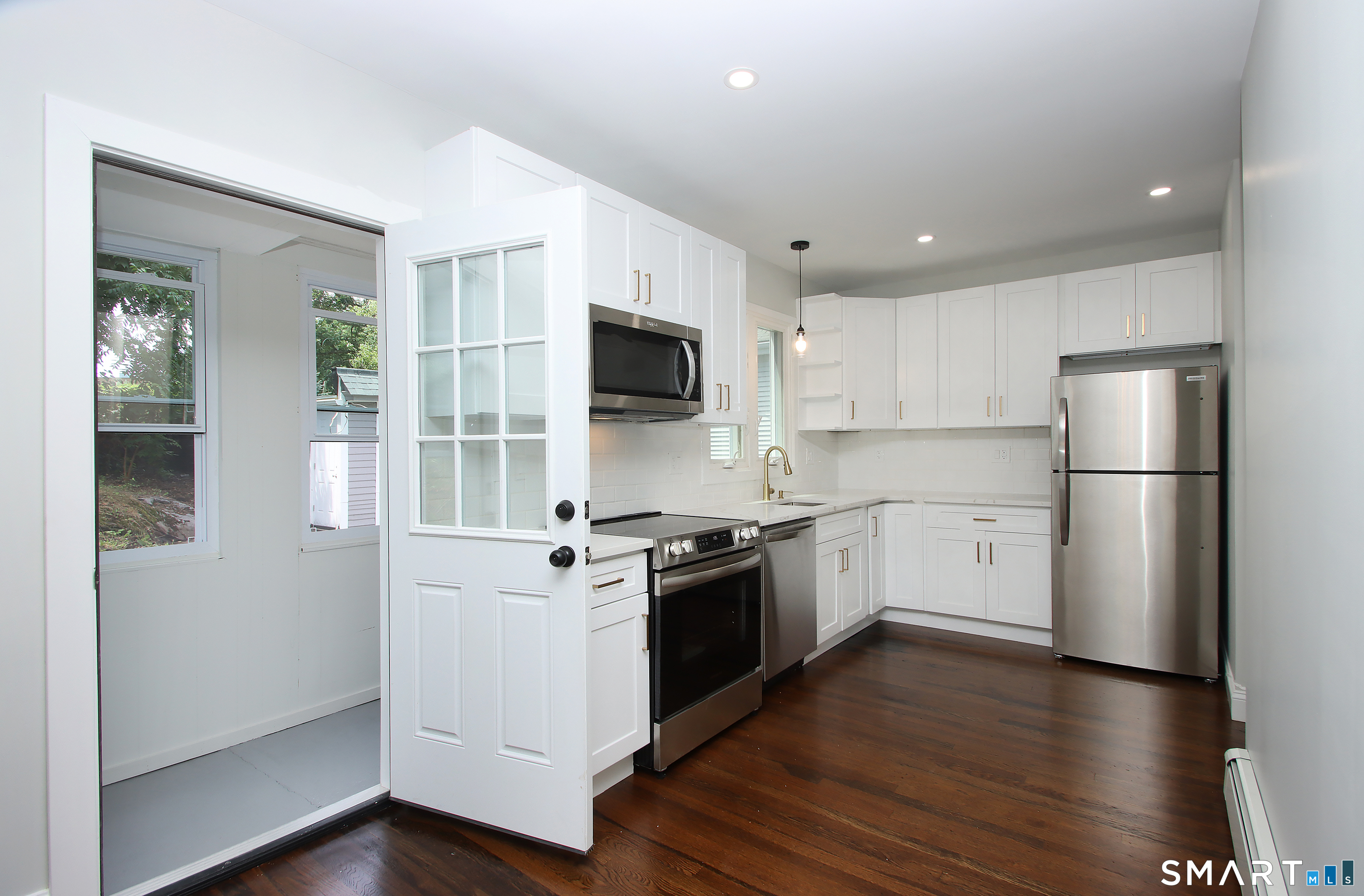 217 Ledgeside Avenue Waterbury, CT 06708 - Photo 10 of 24 a kitchen with a refrigerator stove and wooden floor