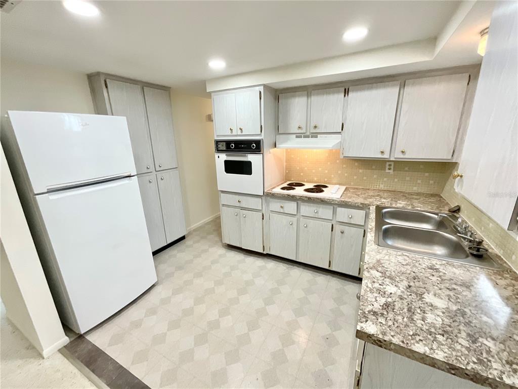 4810 Flora Avenue Holiday, FL 34690 - Photo 3 of 14 a kitchen with white cabinets and white appliances