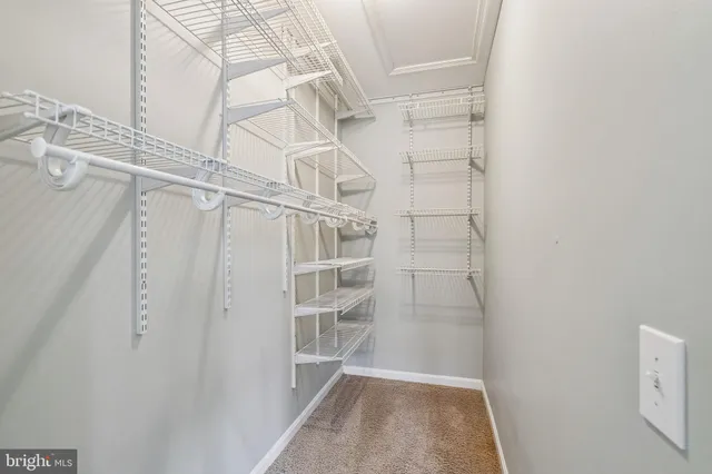 a view of walk in closet with empty racks