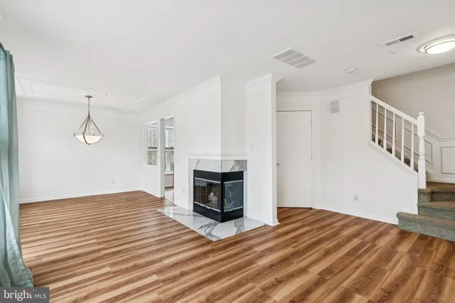 a view of a livingroom with wooden floor and a fireplace