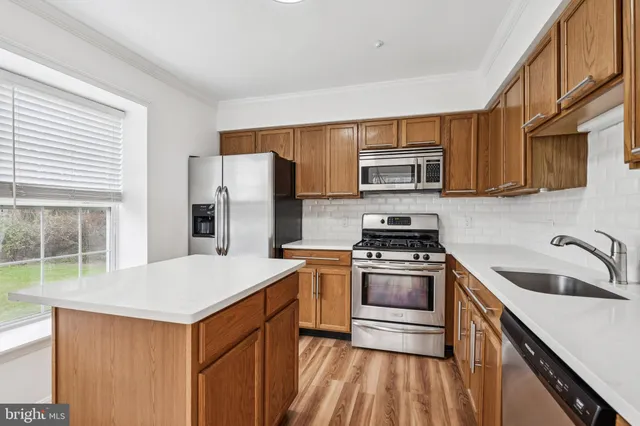 a kitchen with granite countertop a sink stove and refrigerator