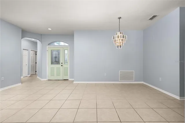 a dining room with furniture a chandelier and window