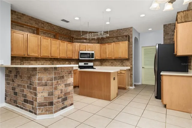 a kitchen with stainless steel appliances a stove sink microwave and cabinets