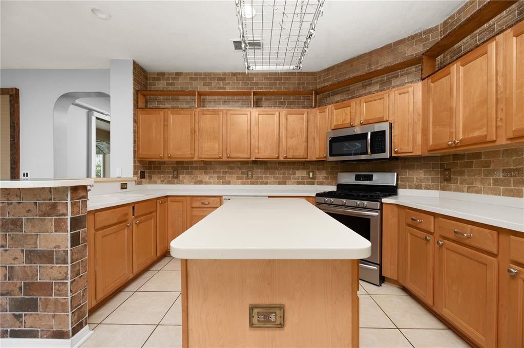 8231 Southwest 79th Court Ocala, FL 34476 - Photo 18 of 39 a kitchen with stainless steel appliances a stove sink microwave and cabinets
