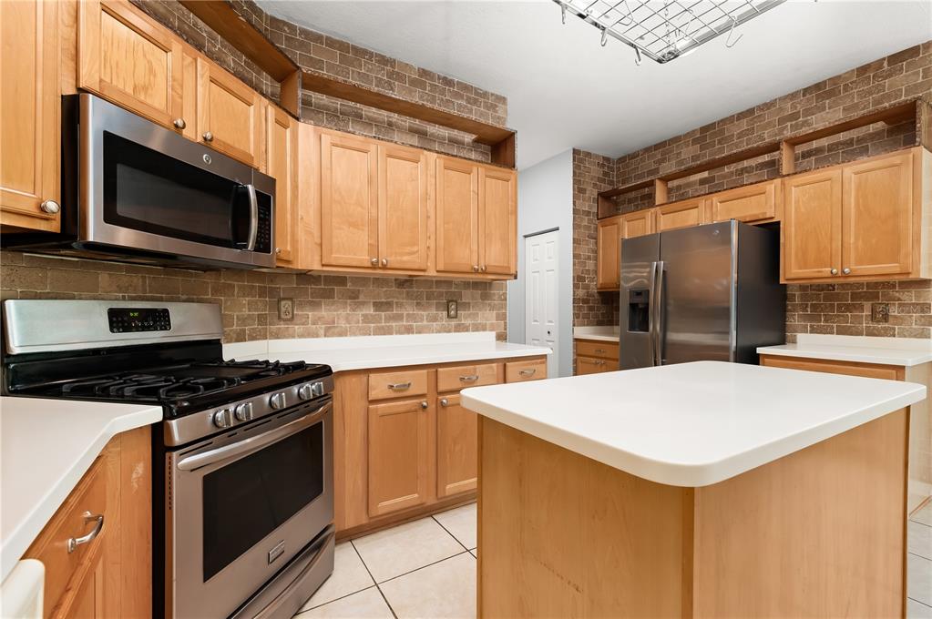 8231 Southwest 79th Court Ocala, FL 34476 - Photo 19 of 39 a kitchen with stainless steel appliances a stove microwave and sink