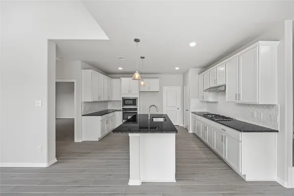 a large kitchen with stainless steel appliances granite countertop a stove a sink and a refrigerator