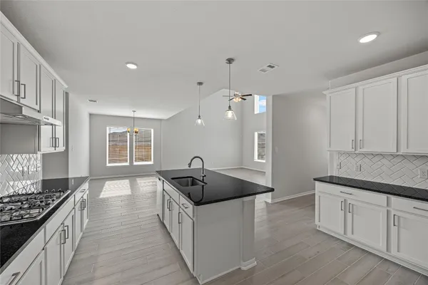 a kitchen with stainless steel appliances granite countertop a sink stove and refrigerator