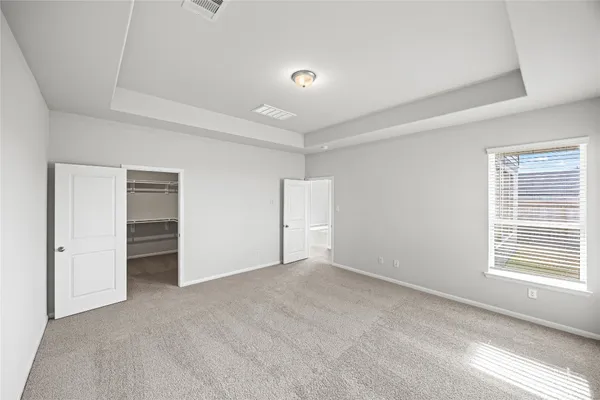 a view of an empty room with closet and a window