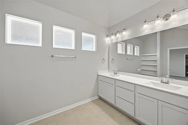 a bathroom with a double vanity sink and mirror