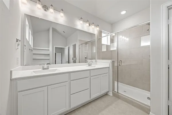 a bathroom with a shower sink and mirror