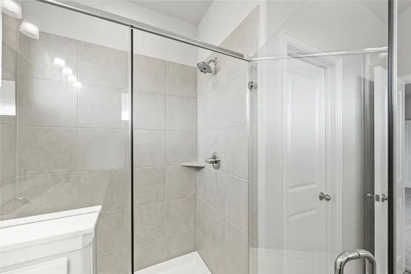 a bathroom with a shower and a glass door