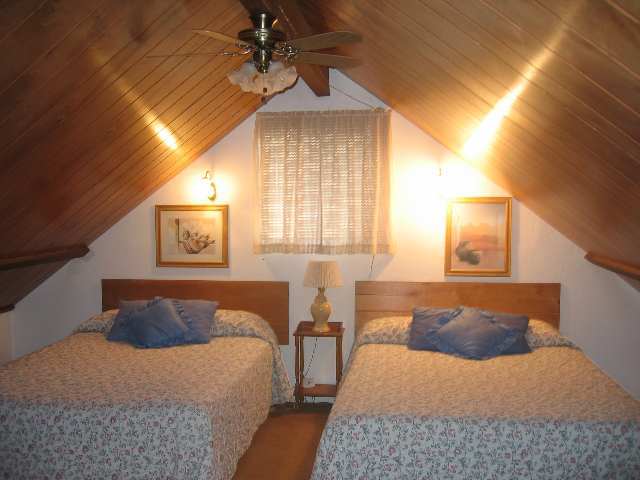 2052 Shot Gun Road Overgaard, AZ 85933 - Photo 4 of 5 a bedroom with a bed lamps and wooden floor