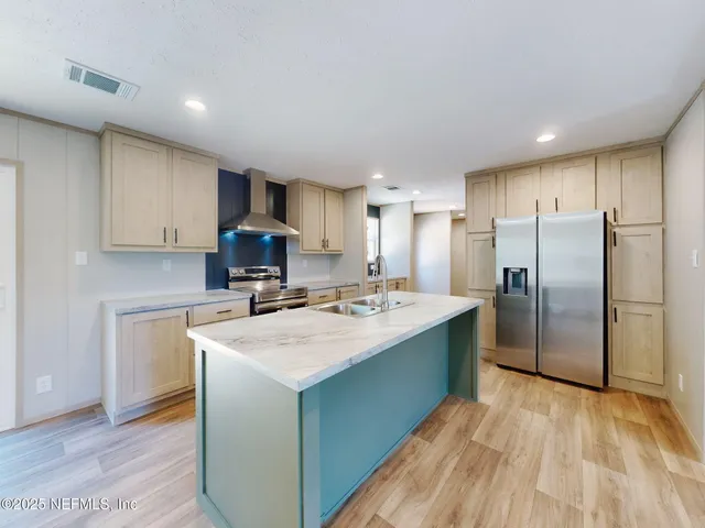 a kitchen with stainless steel appliances granite countertop a sink stove and refrigerator