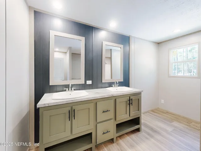 a spacious bathroom with a double vanity sink and mirror