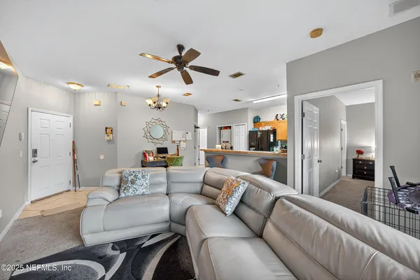 a living room with furniture and a view of kitchen