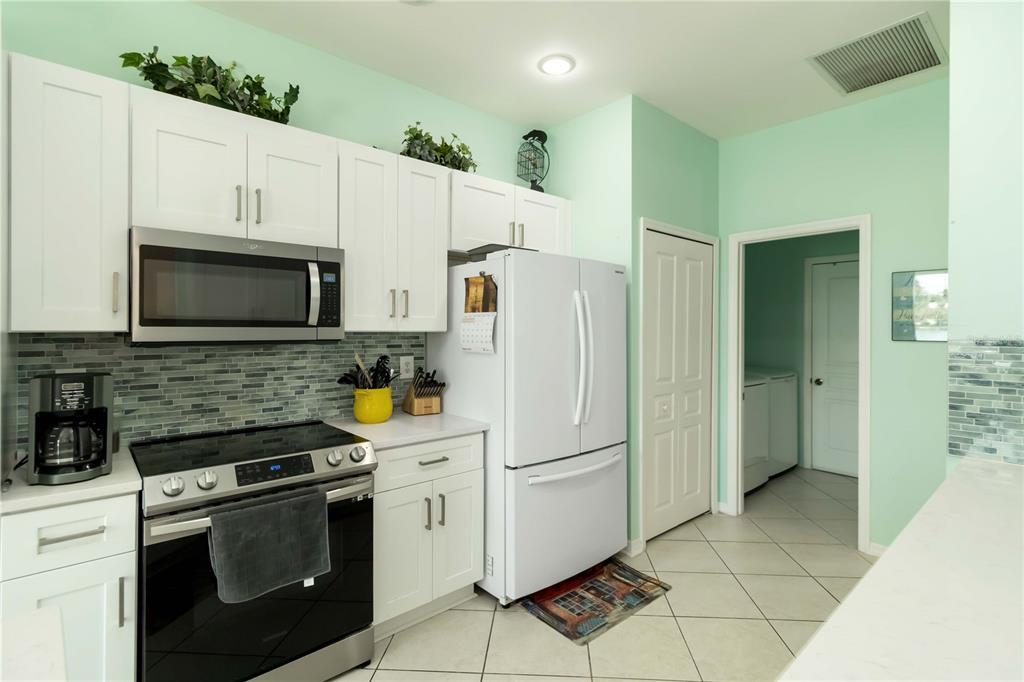 357 Fareham Drive Venice, FL 34293 - Photo 8 of 34 a kitchen with white cabinets and white appliances