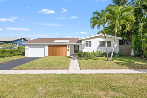 a view of a house with backyard and tree s