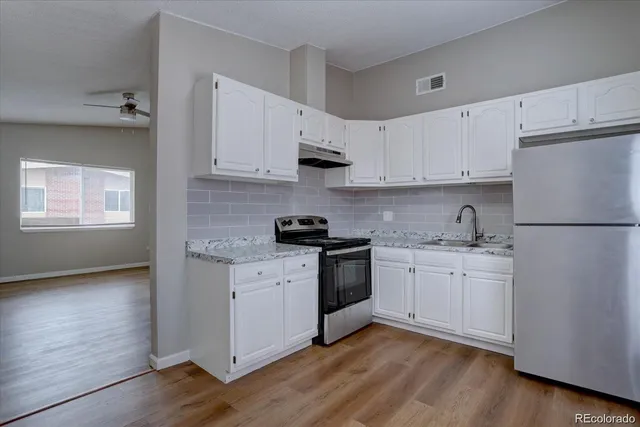 a kitchen with granite countertop white cabinets and white appliances