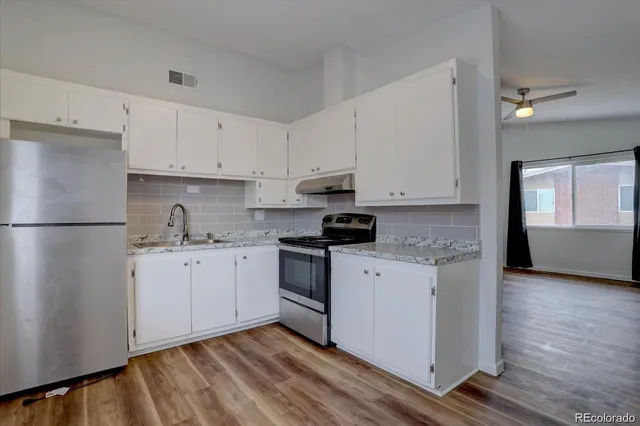 a kitchen with granite countertop white cabinets and white appliances