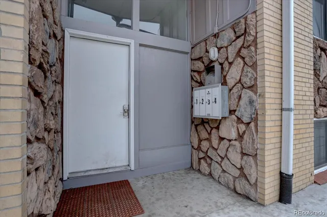 a view of a wooden door with a bench and a shower