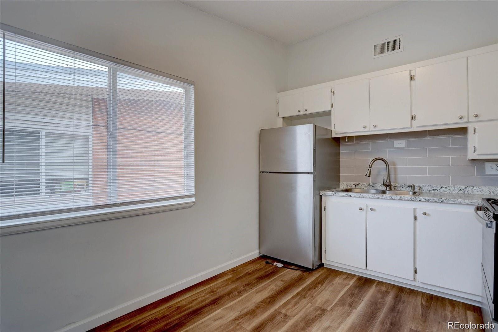 2938 Eliot Circle, Unit 2 Westminster, CO 80030 - Photo 5 of 28 a kitchen with a sink a refrigerator and cabinets