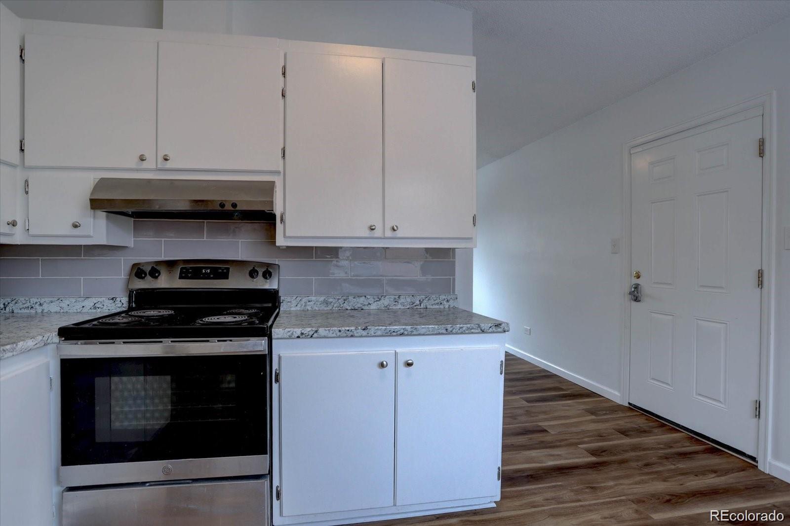 2938 Eliot Circle, Unit 2 Westminster, CO 80030 - Photo 6 of 28 a kitchen with granite countertop cabinets and steel stove