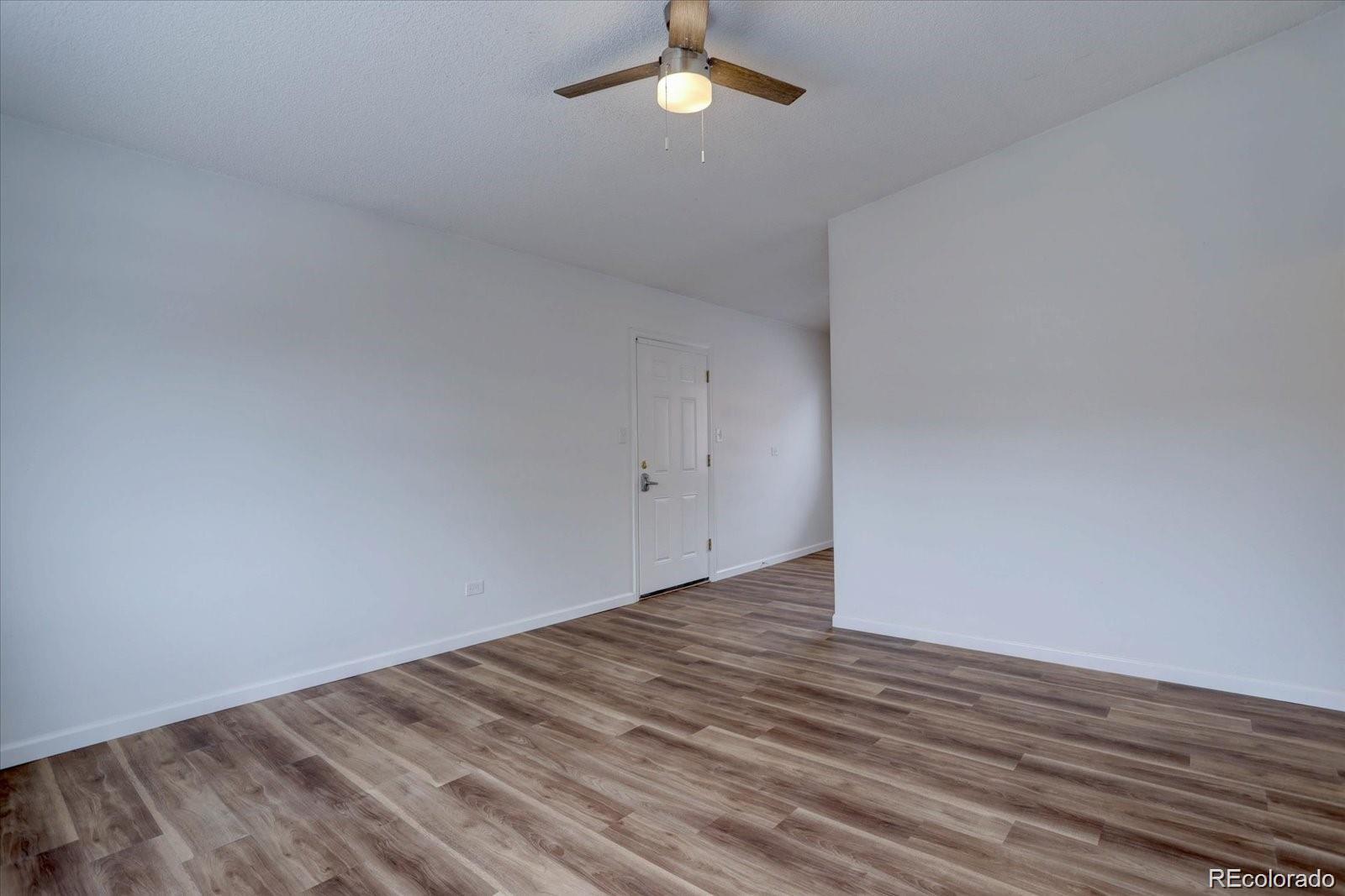 2938 Eliot Circle, Unit 2 Westminster, CO 80030 - Photo 8 of 28 wooden floor in an empty room with a window