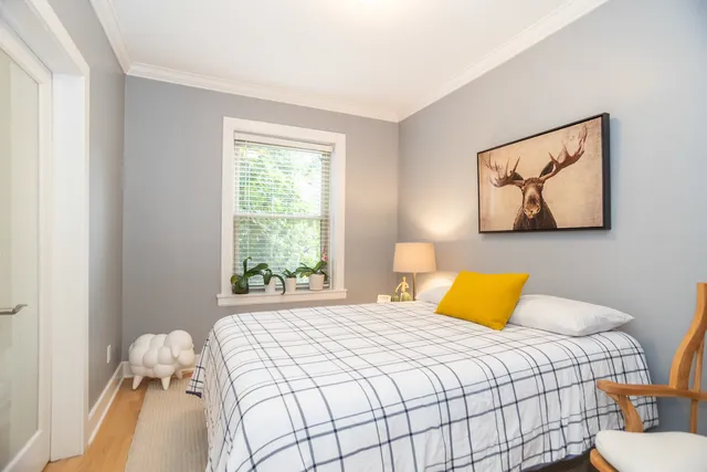 a bedroom with a bed and a painting on the wall