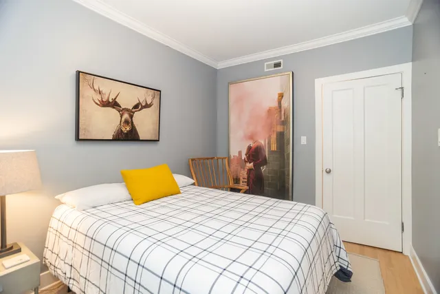 a bedroom with a bed and painting on the wall