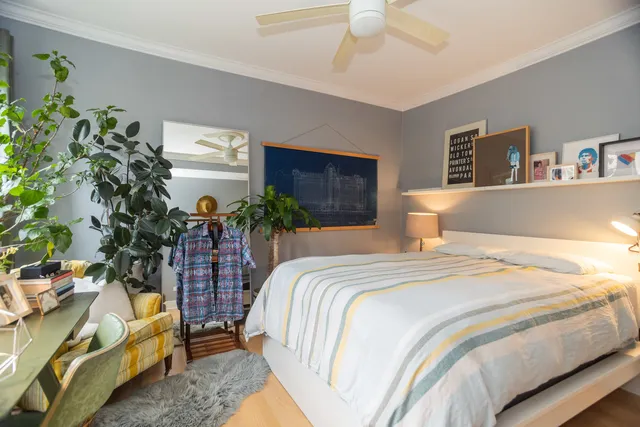 a bedroom with a bed and a potted plant