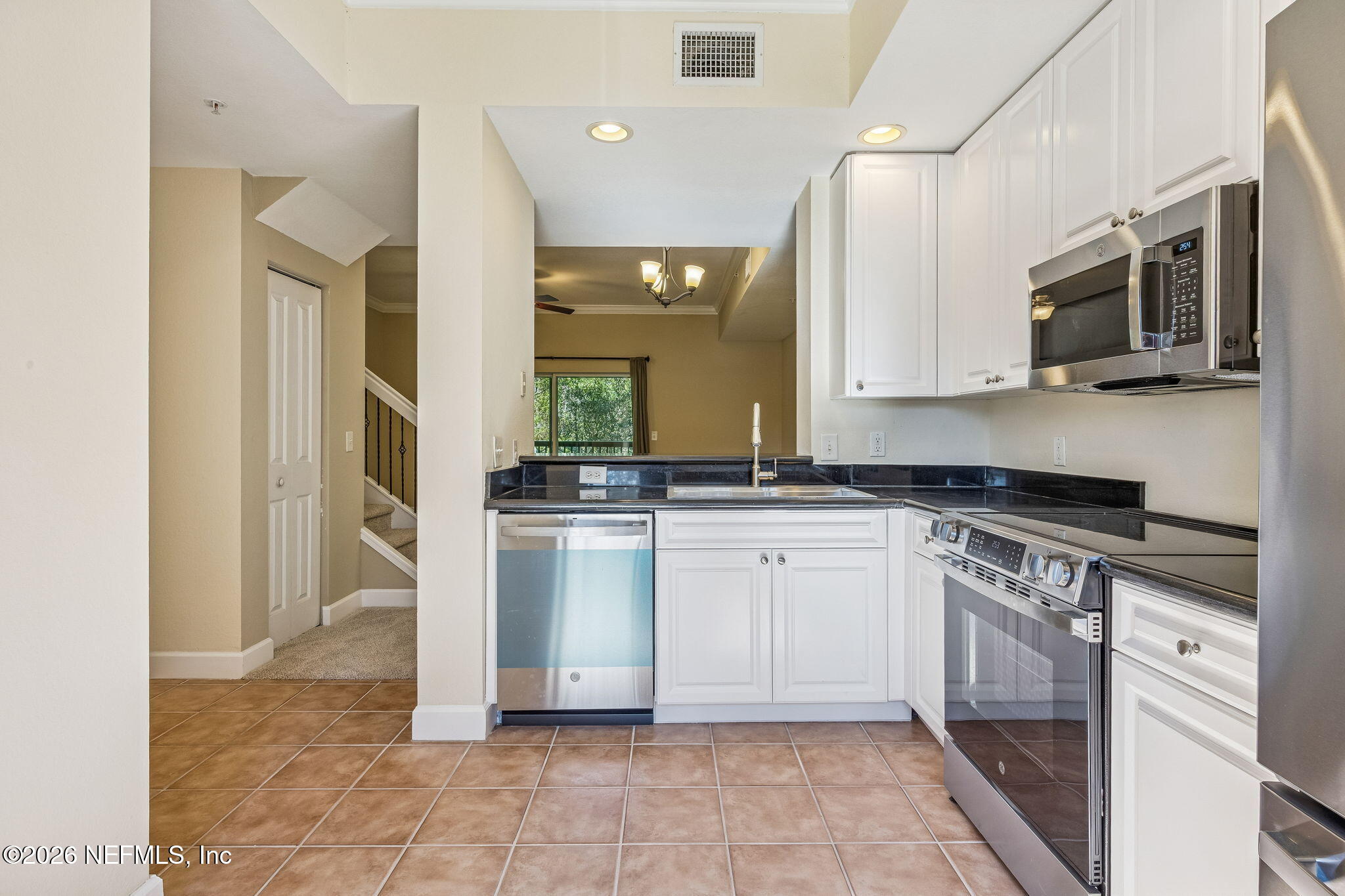 9745 Touchton Road, Unit 2125 Jacksonville, FL 32246 - Photo 11 of 50 a kitchen with stainless steel appliances granite countertop a stove a sink and a microwave