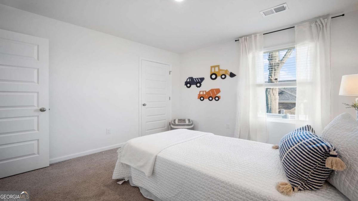 149 Timber Road Statesboro, GA 30458 - Photo 28 of 42 a bedroom with a white bed and a painting on the wall