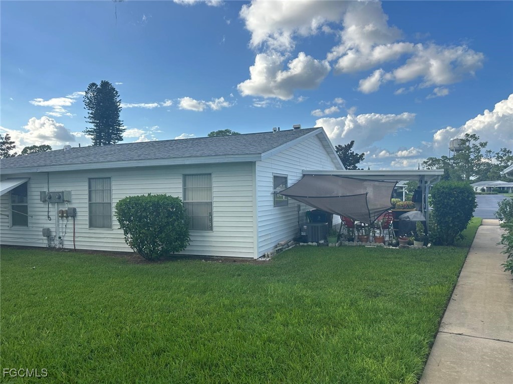 19 Pinewood Boulevard Lehigh Acres, FL 33936 - Photo 24 of 25 a front view of a house with a garden and yard