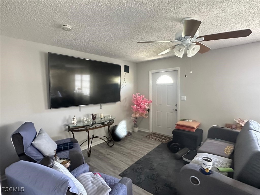 19 Pinewood Boulevard Lehigh Acres, FL 33936 - Photo 3 of 25 a living room with furniture and a flat screen tv