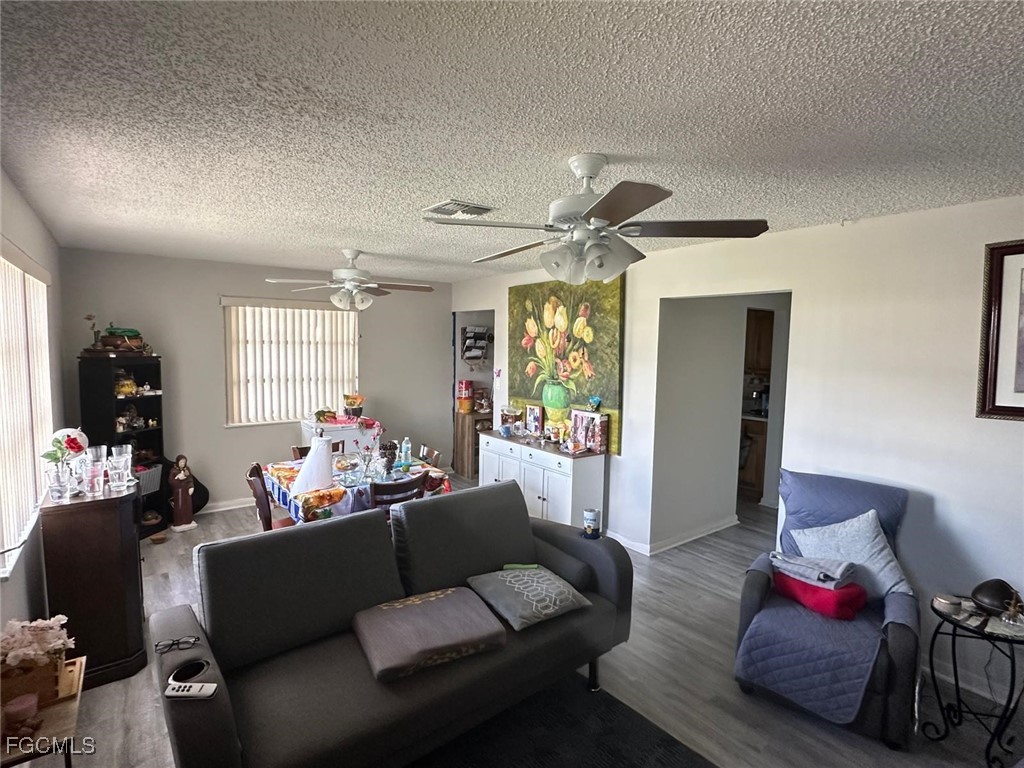19 Pinewood Boulevard Lehigh Acres, FL 33936 - Photo 4 of 25 a living room with furniture and a chandelier