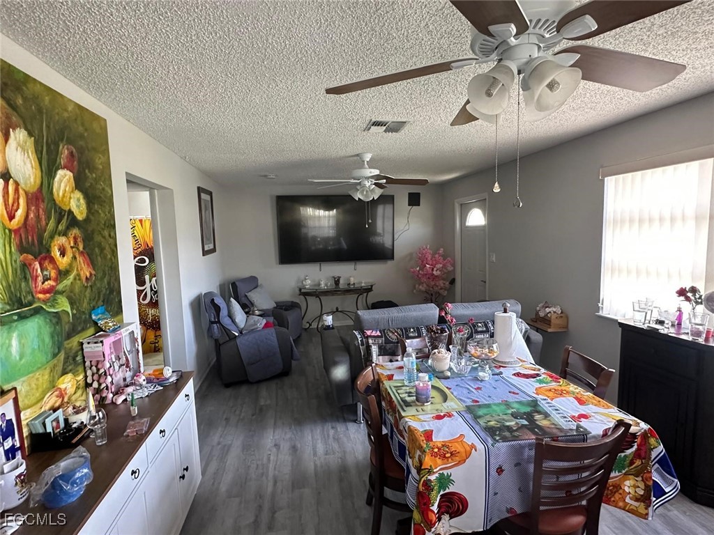 19 Pinewood Boulevard Lehigh Acres, FL 33936 - Photo 5 of 25 a view of a dining room with furniture and a flat screen tv