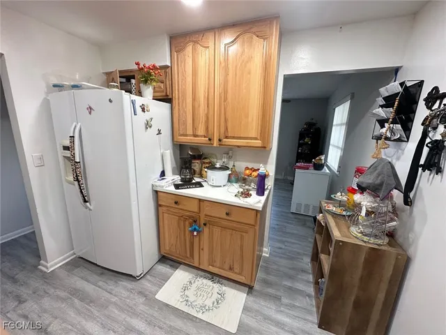 a kitchen with refrigerator and white cabinets