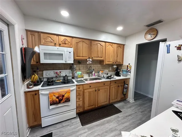 a kitchen with stainless steel appliances a stove refrigerator and sink