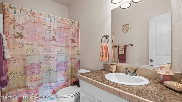 a bathroom with a granite countertop sink mirror vanity and toilet