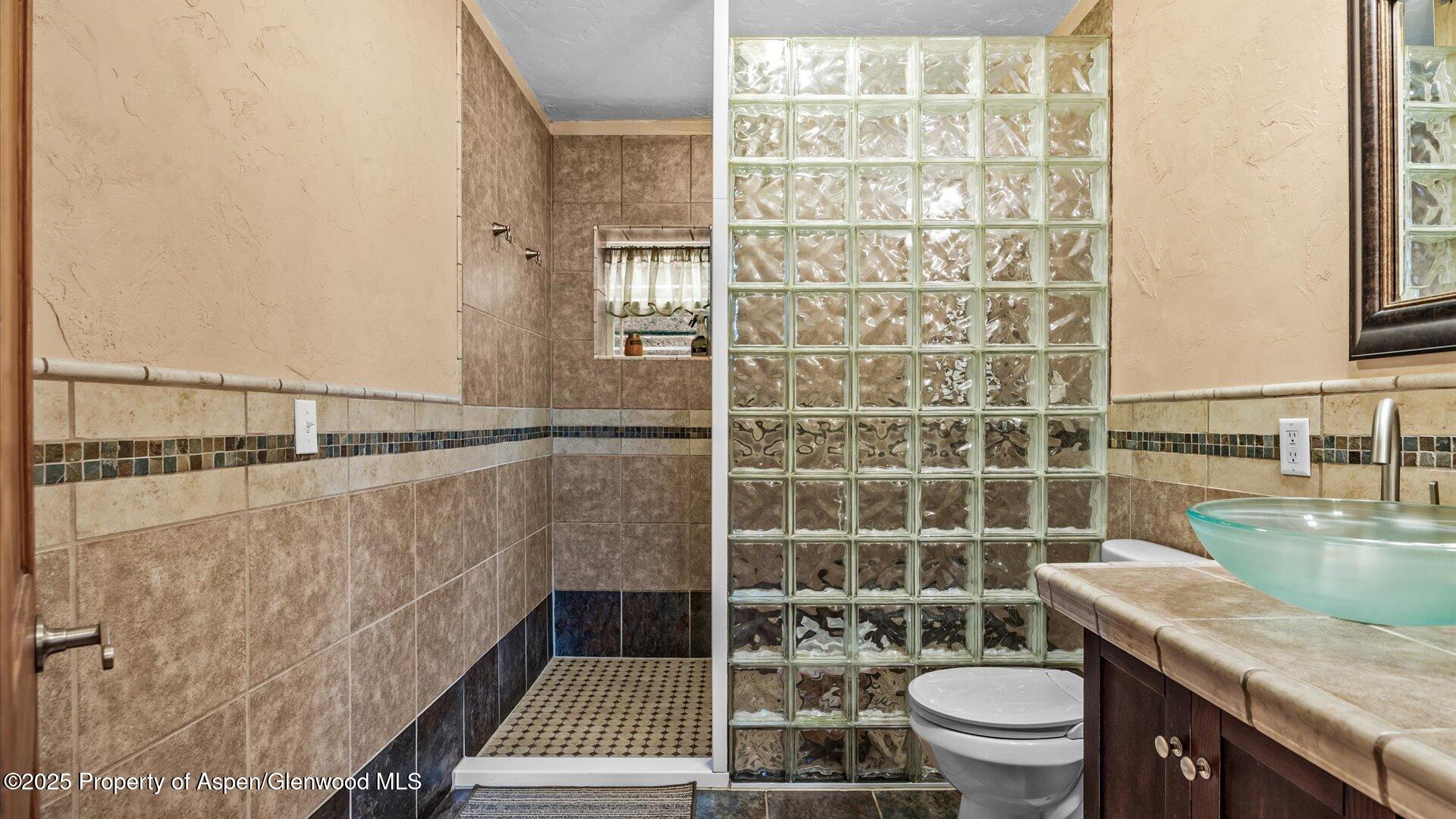 40380 D Road Crawford, CO 81415 - Photo 46 of 52 a bathroom with a granite countertop sink a toilet and a shower