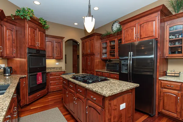 a kitchen with stainless steel appliances granite countertop a stove refrigerator and cabinets
